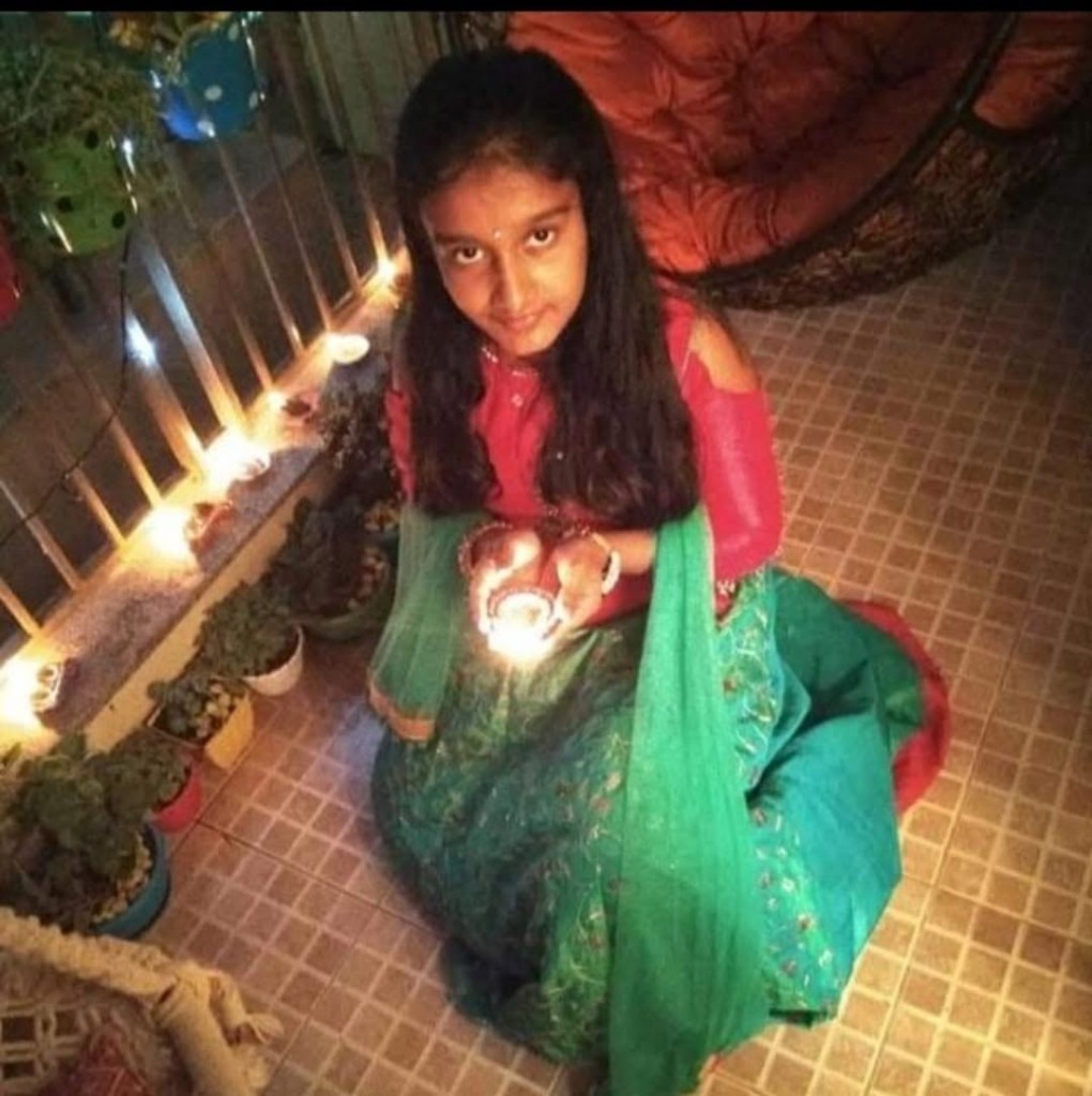 Veda Manchana holding a glowing diya